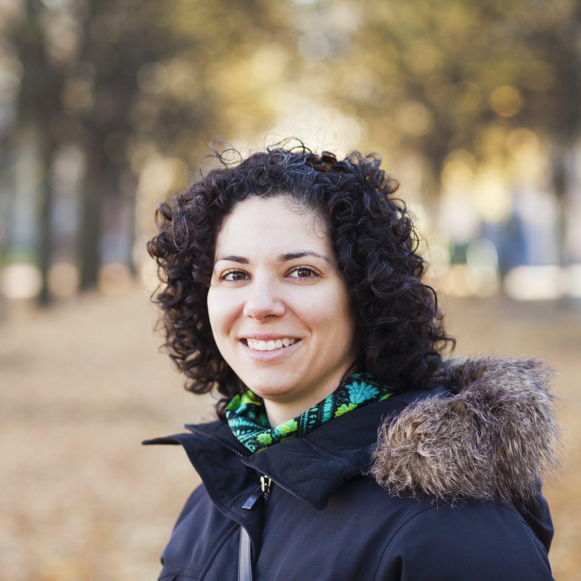 portrait of happy woman with curly hair at park