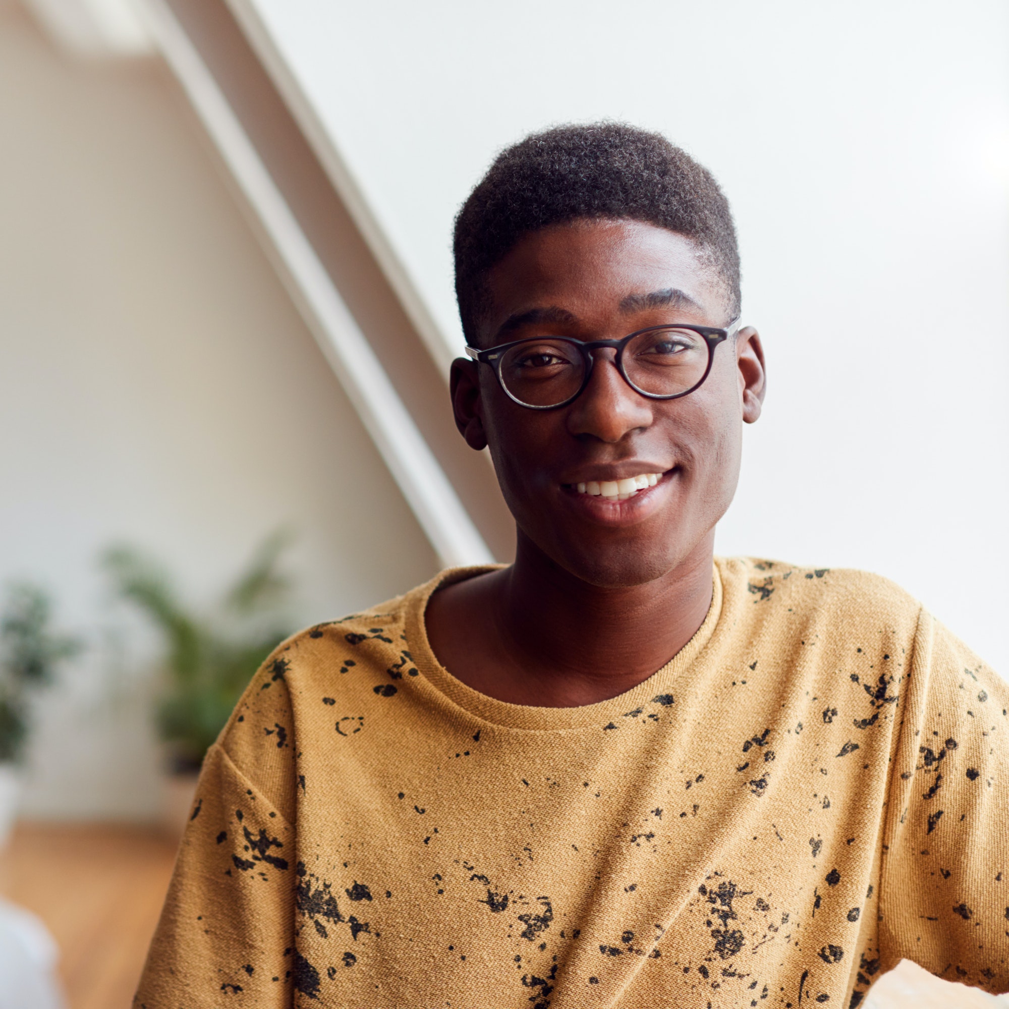 portrait of smiling young man in loft apartment